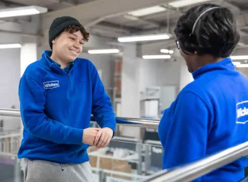Two workers at Wickes smiling at each other