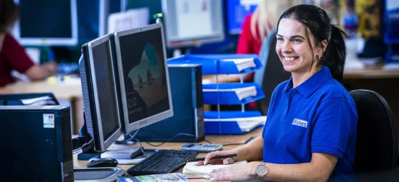 Employee at Wickes working in an office looking happy
