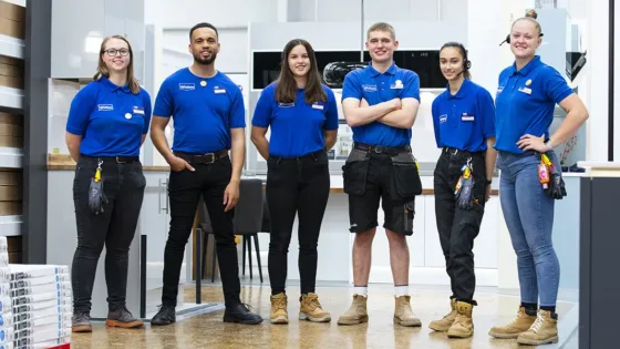 Team of workers in a Wickes store standing in a group and looking happy