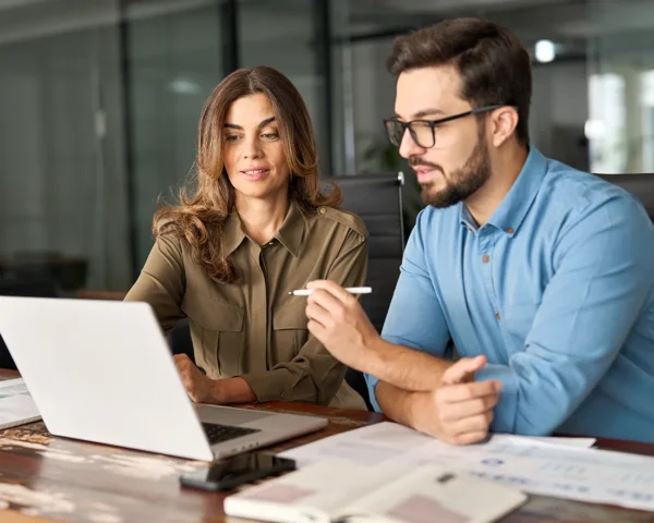 colleagues chatting while looking at laptop